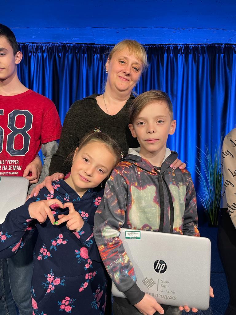 Ukranian family posing for a photograph after just receiving a laptop.